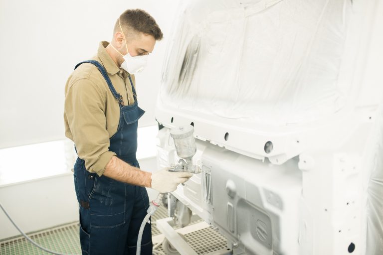 Mechanic Painting Truck In Garage